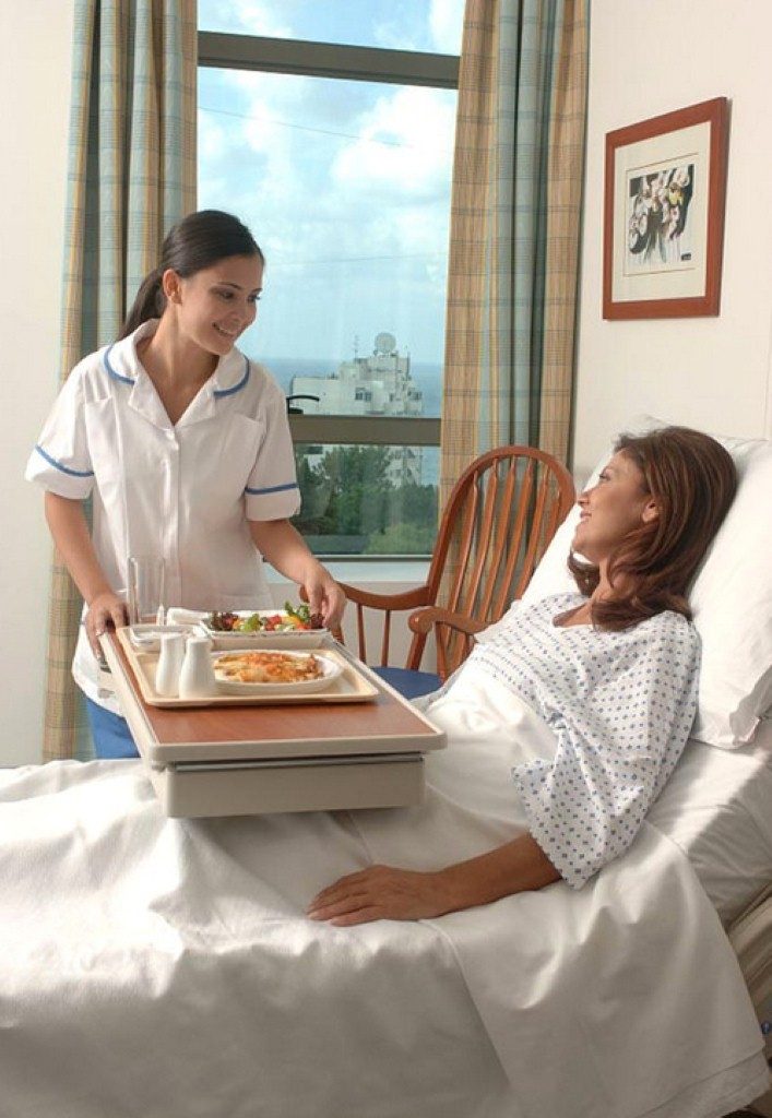 hospital staff delivers meal to patient
